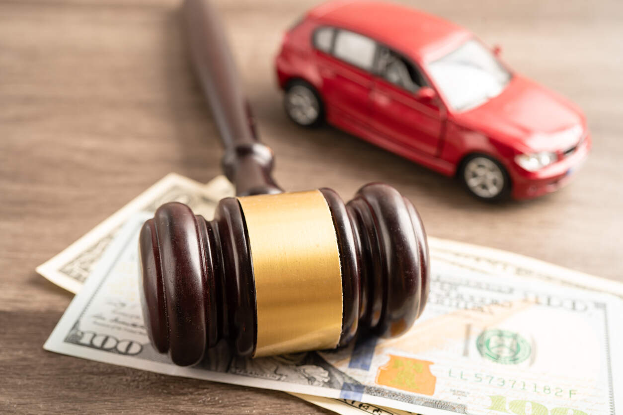 Legal concept of Texas car accident laws with gavel, money, and toy car on wooden table
