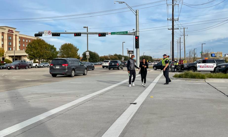 Police officer speaking with witnesses after a car accident at a Texas intersection, gathering statements to support a personal injury claim.